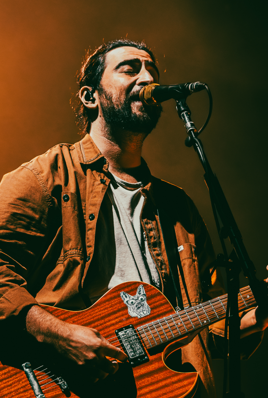 Singer-songwriter playing acoustic guitar with warm lighting